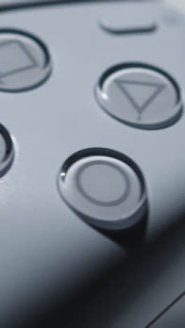 Vertikales-Video-Nahaufnahme-Playstation-Videospielcontroller-Rotierender-Weißer-Hintergrund-1